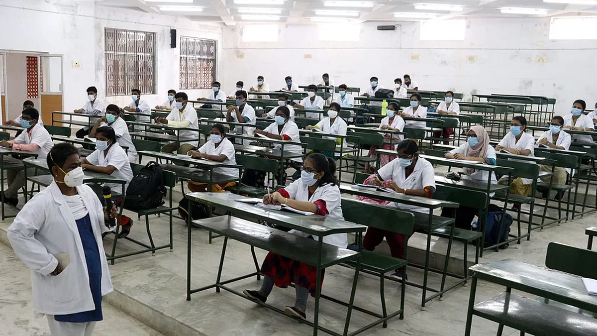 Medical and nursing students in white coats sitting in a classroom