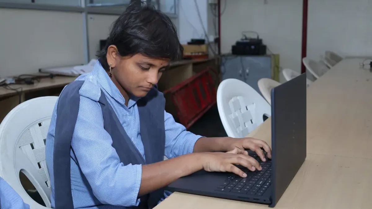 A specially-abled student studying on a laptop at an engineering college in India