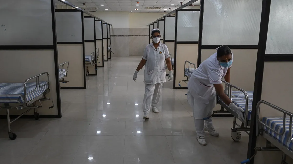 Two nurses working in a hospital ward in India