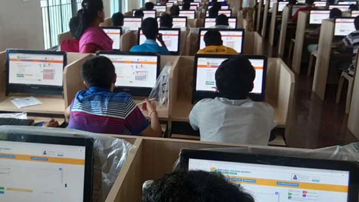 Students taking a computer-based entrance exam at a test centre in India