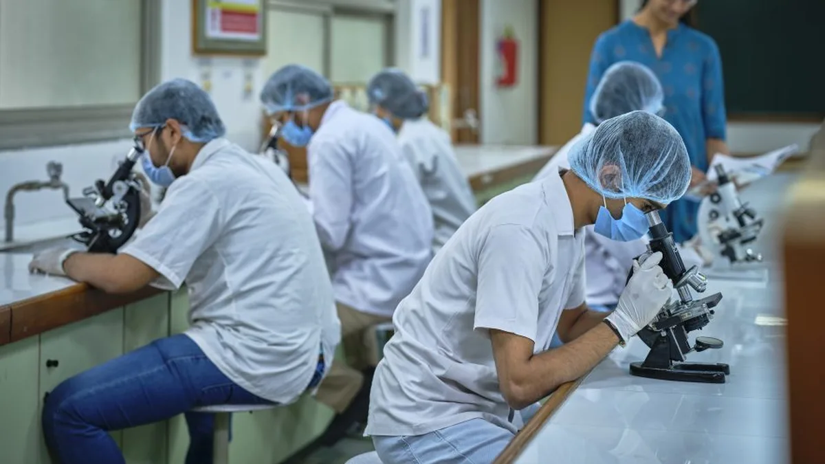 Science students working with microscopes in a university laboratory in India