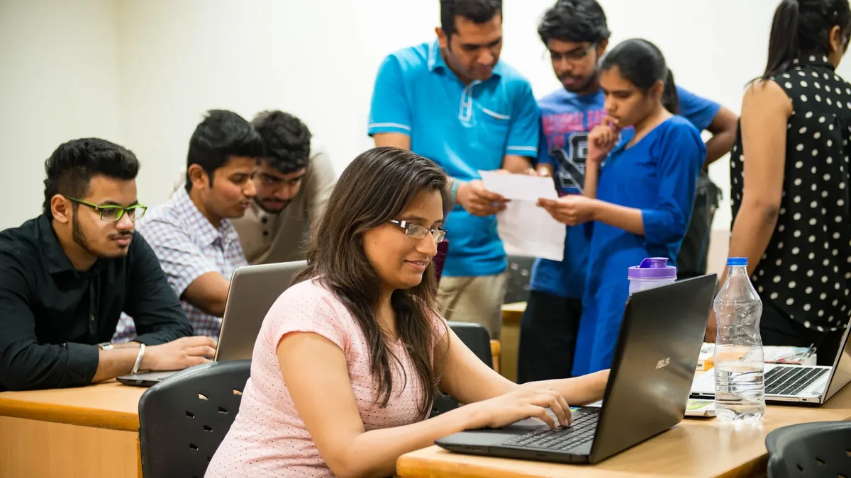 Indian college students using laptops, applying for scholarships online