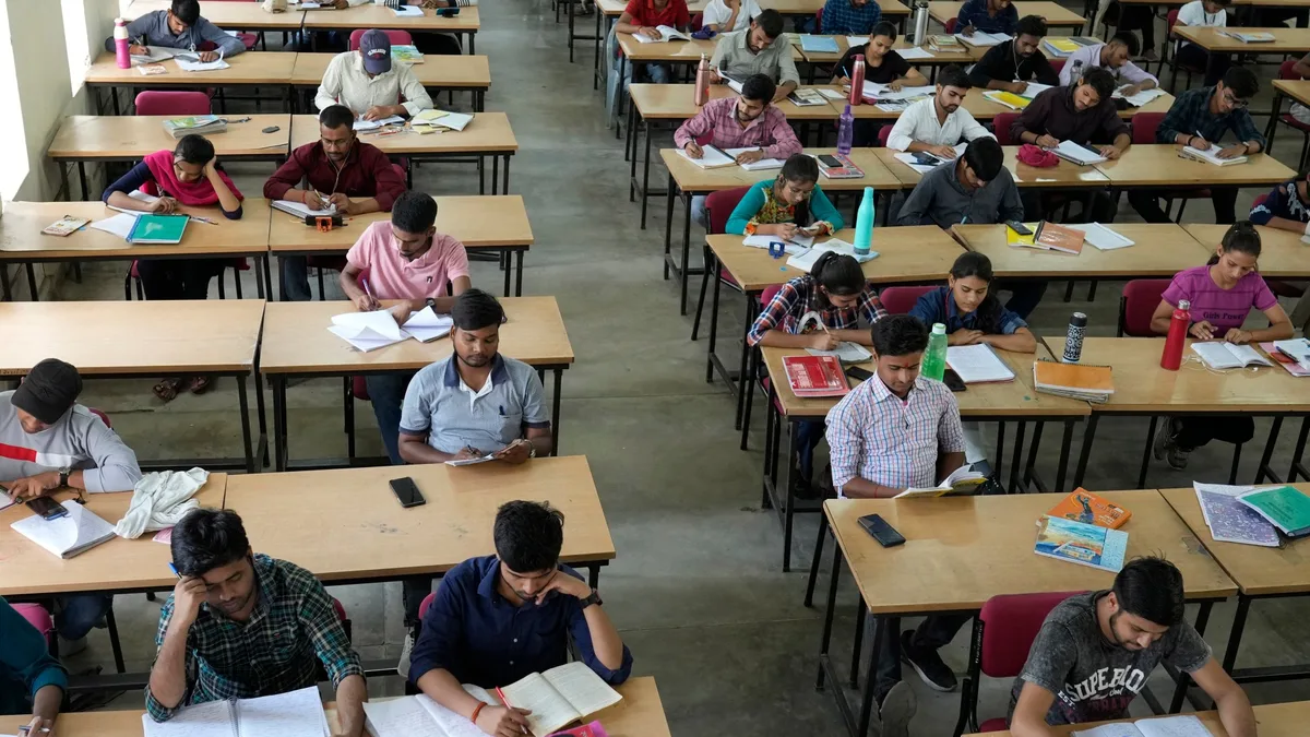 Indian university students sitting in an examination hall during a written test