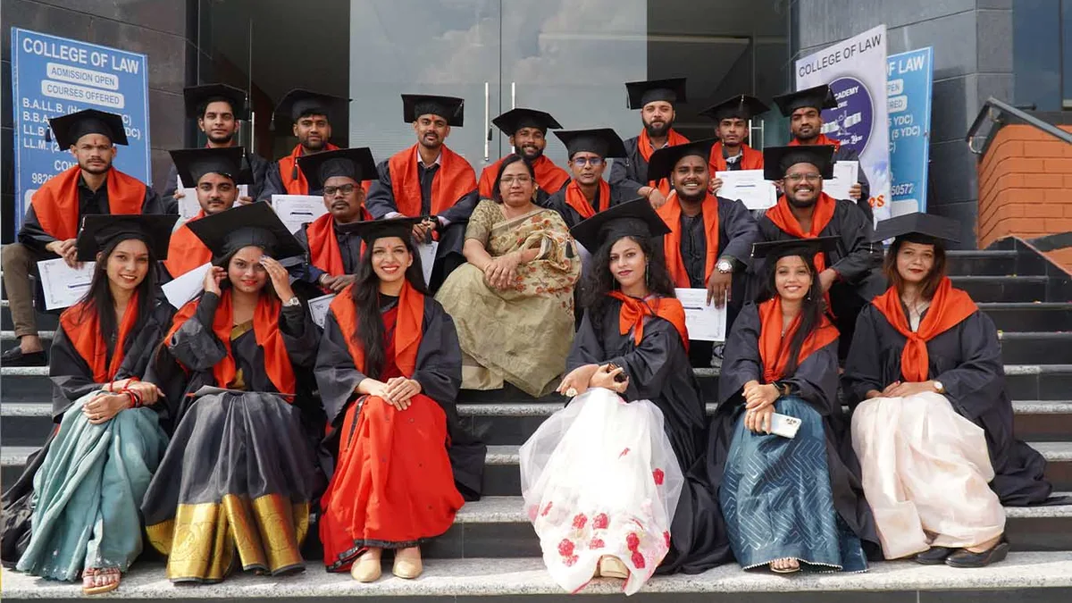 Law graduates in black gowns and caps posing with certificates at a convocation