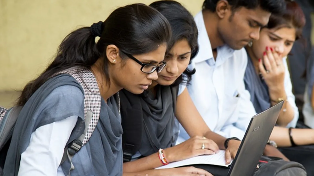 Indian college students looking at a laptop while applying for scholarships online