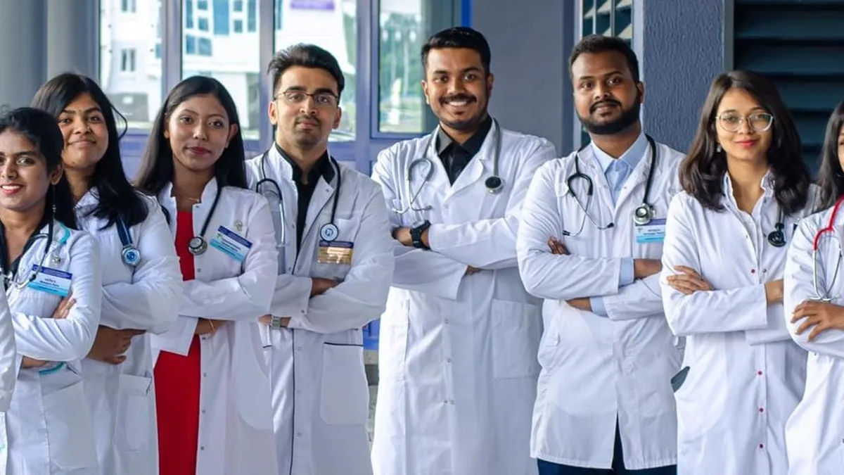 Medical students in white coats standing together outside a medical college in India