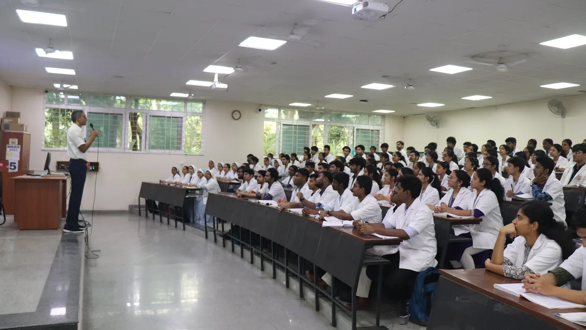 Medical students in white coats attending a lecture at a medical college in India
