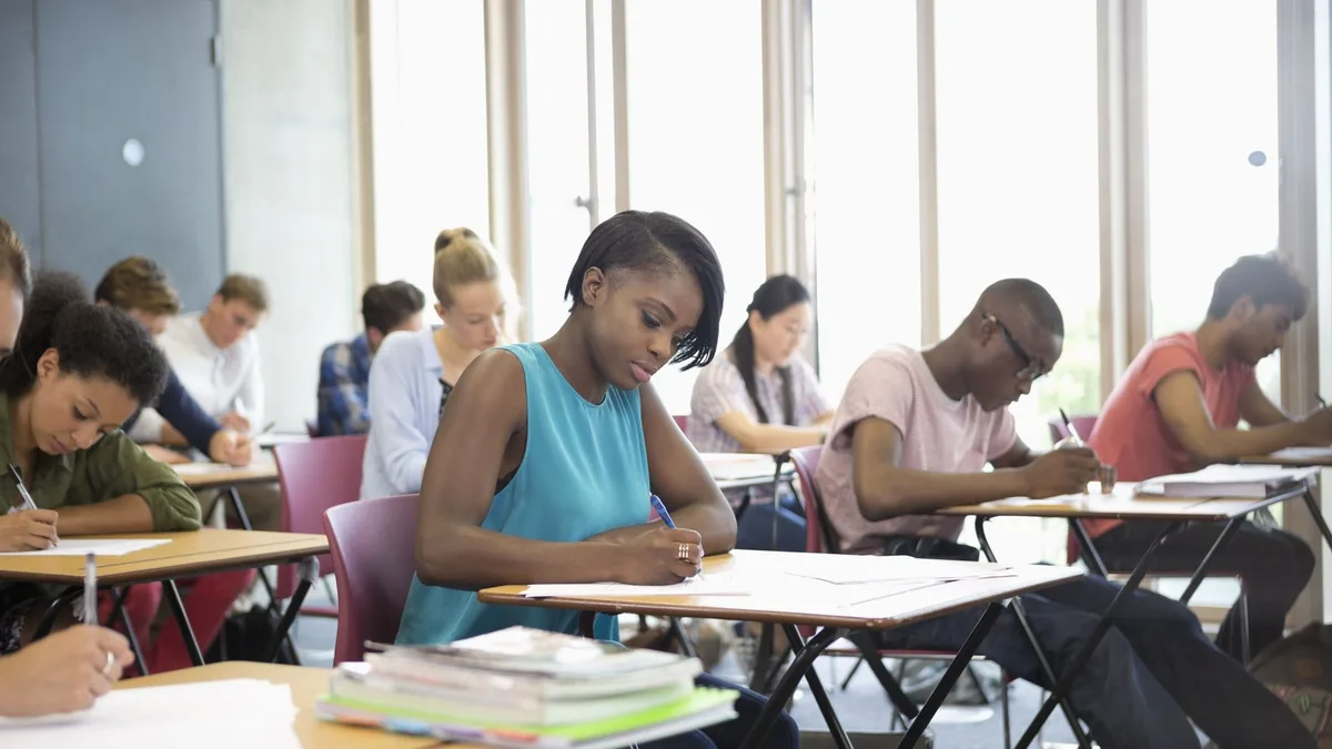 University students writing an exam in a hall